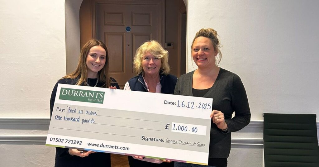 Lily presents a cheque to 'Feed All Children' from the Durrants Charitable Foundation.